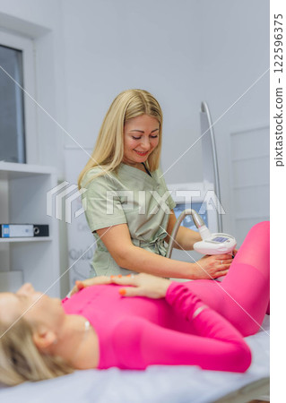 Lpg massage procedure. Hands of therapist holding lipomassage tool. Close up, selective focus. 122596375