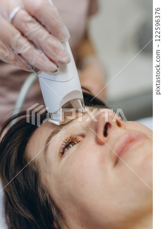 Professional cosmetologist performing LPG facial skin massage for rejuvenation in beauty salon. Professional cosmetologist performing LPG facial skin massage for rejuvenation in beauty salon. 122596376