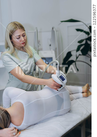 Lpg massage procedure. Hands of therapist holding lipomassage tool. 122596377