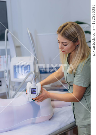 Lpg massage procedure. Hands of therapist holding lipomassage tool. 122596383