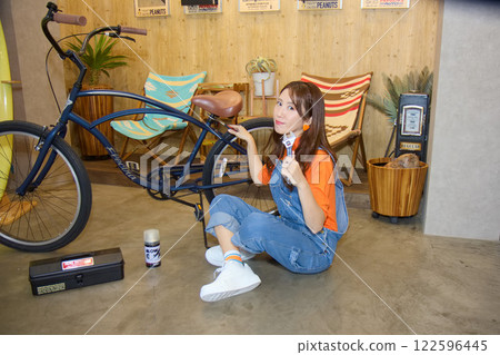 Female worker repairing a bicycle Female worker repairing a bicycle 122596445