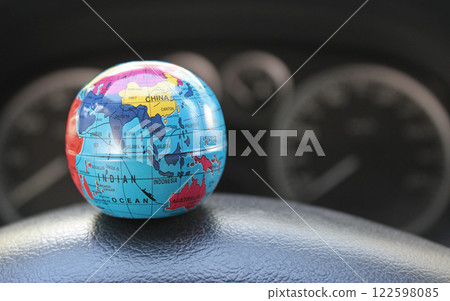 Earth Globe With Mapped Trade And Travel Directions Between Continents  With Blurred Car Dashboard. Car travel illustrative stock photo  122598085