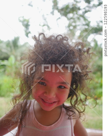 Portrait of a little girl with curly hair in the park 122598193