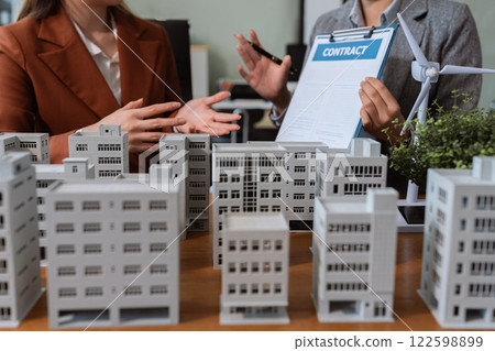 House model with agent asking costumer for contract to buy, get insurance or loan real estate or property. House model with agent asking costumer for contract to buy, get insurance or loan real estate or property. 122598899