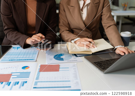 Business team analyzing documents, graphs, and data with a laptop, tablet, and smartphone. Collaboration, strategy, and success in a modern office. Business team analyzing documents, graphs, and data with a laptop, tablet, and smartphone. Collaboration, strategy, and success in a modern office. 122598918