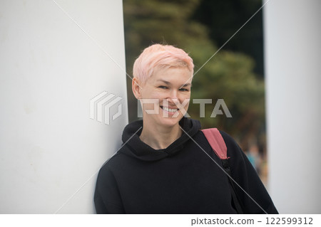 Joyful mid adult woman in city park. Mature model traveler with elegant short haircut Joyful mid adult woman in city park. Mature model traveler with elegant short haircut 122599312