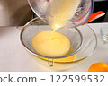 Pastry chef cooking tangerine pie filtering orange cream filling through sieve. 122599532