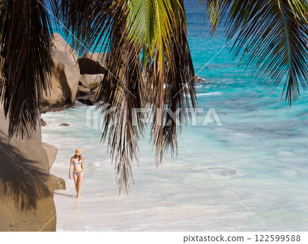Cute woman walking on stunning white sand beach Cute woman walking on stunning white sand beach 122599588