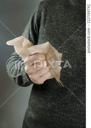 man is about to blow his nose with a tissue man is about to blow his nose with a tissue 122599742