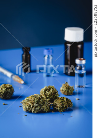 cannabis buds and flasks on a blue table cannabis buds and flasks on a blue table 122599752