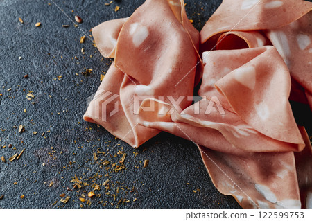 closeup of some thin slices of mortadella closeup of some thin slices of mortadella 122599753