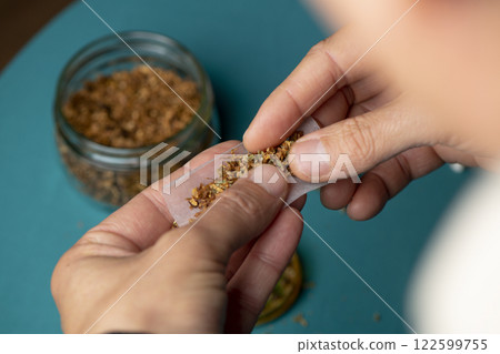 man making a joint with cannabis and tobacco 122599755