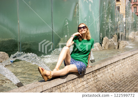 Happy 30s young female tourist is exploring new city. Woman sitting on central square in Wroclaw old town in Poland. High quality photo, summer time. Vacation concept Happy 30s young female tourist is exploring new city. Woman sitting on central square in Wroclaw old town in Poland. High quality photo, summer time. Vacation concept 122599772