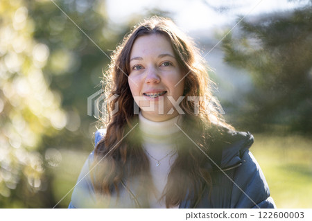 Portrait of smiling teenage girl with braces in nature setting Portrait of smiling teenage girl with braces in nature setting 122600003