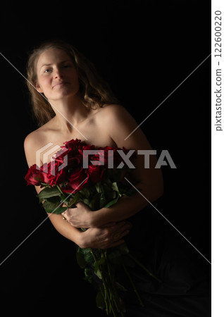Sensual beautiful woman with bare shoulders and red roses on a dark studio background 122600220