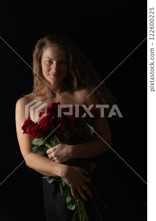 Sensual beautiful woman with bare shoulders and red roses on a dark studio background Sensual beautiful woman with bare shoulders and red roses on a dark studio background 122600225