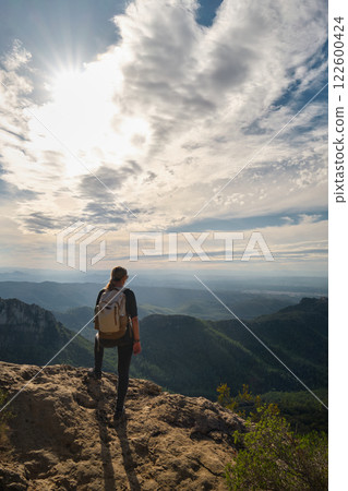 Woman with a backpack on her back on top of a mountain 122600424