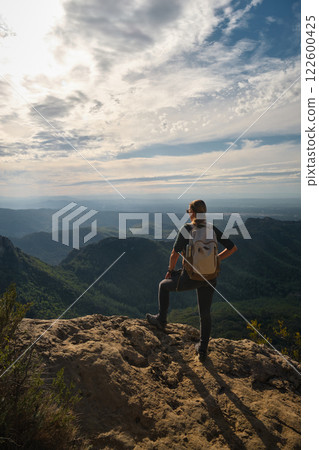 Woman with a backpack on her back on top of a mountain Woman with a backpack on her back on top of a mountain 122600425