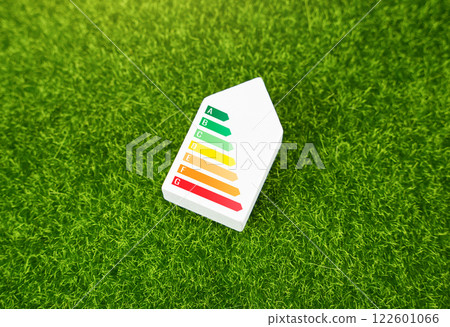 European Union energy label on the house on the green grass. Energy consumption labelling scheme. Self-sufficiency and economy of housing. High energy efficiency. European Union energy label on the house on the green grass. Energy consumption labelling scheme. Self-sufficiency and economy of housing. High energy efficiency. 122601066