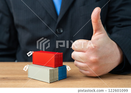 Businessman showing thumbs up and containers with price tags. Selling containers and confiscated cargo. Marking up duties and protective tariffs on imports. Profit from trade. 122601099