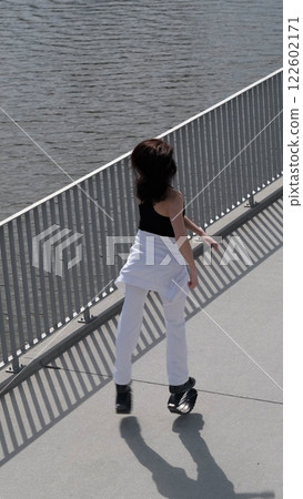 A woman in motion exercises with Kangoo Jumps shoes near the water, embracing a dynamic fitness routine. The increasing popularity of rebound workouts showcases the shift towards fun and innovative 122602171