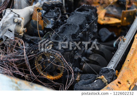A close-up of the burnt-out engine compartment of a car. 122602232