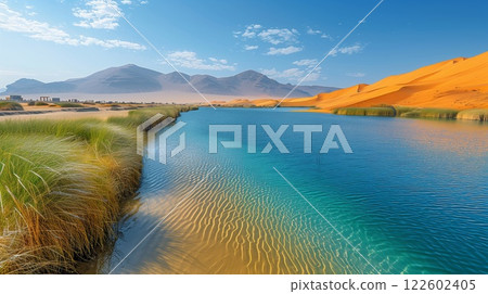 Golden sand dunes and vibrant green reeds surrounding a clear blue desert oasis, with distant mountains under a bright sky and soft ripples reflecting sunlight on the water Golden sand dunes and vibrant green reeds surrounding a clear blue desert oasis, with distant mountains under a bright sky and soft ripples reflecting sunlight on the water 122602405