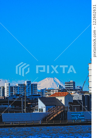 A residential area under clear blue skies and snow-capped Mount Fuji 122602631