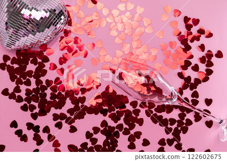 Minimalist disco heart Champagne Glass Filled spilling Red Glitter on Pink Backdrop 122602675