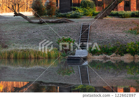 Autumn landscape with wooden stairs and boardwalk reflection in lake water 122602897