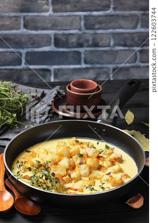 pollock cubes poached in cream saffron sauce pollock cubes poached in cream saffron sauce 122603744