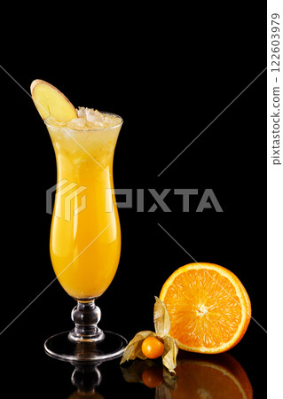 Closeup glass of fresh orange juice with ice decorated with ginger isolated at black background. 122603979