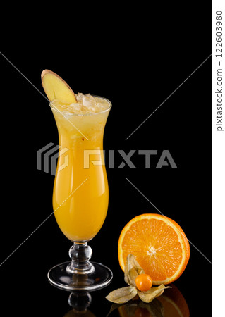 Closeup glass of fresh orange juice with ice decorated with ginger isolated at black background. Closeup glass of fresh orange juice with ice decorated with ginger isolated at black background. 122603980