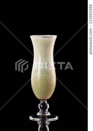 Glass of fresh melon milkshake isolated at black background. Glass of fresh melon milkshake isolated at black background. 122603988