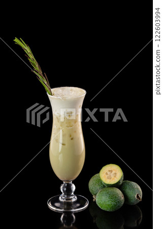 Glass of fresh pear juice decorated with feijoa and rosemary isolated at black background. Glass of fresh pear juice decorated with feijoa and rosemary isolated at black background. 122603994