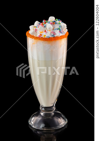 Glass of tasty sweet milkshake decorated with marshmallow isolated at black background. 122604004