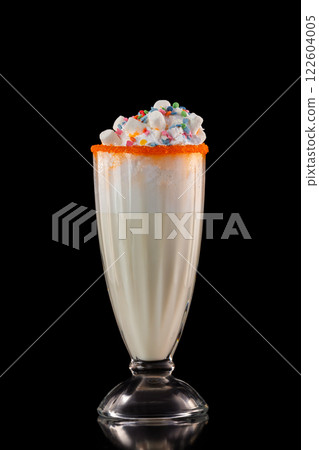 Glass of tasty sweet milkshake decorated with marshmallow isolated at black background. 122604005