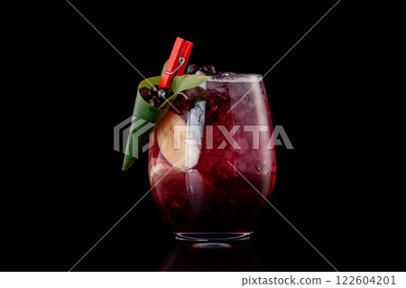 Glass of berries sangria with red wine, black currant, lemon and banana isolated at black background. 122604201