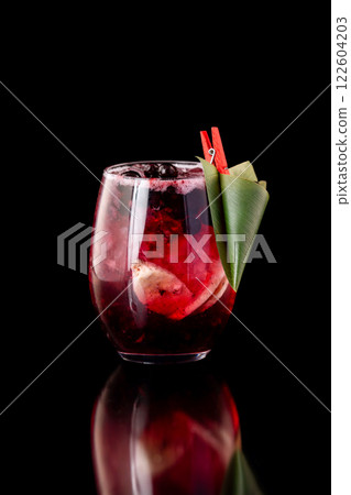 Glass of berries sangria with red wine, black currant, lemon and banana isolated at black background. Glass of berries sangria with red wine, black currant, lemon and banana isolated at black background. 122604203