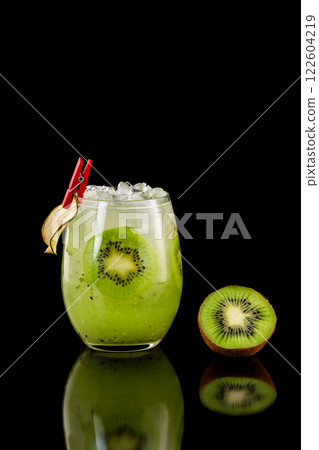 Closeup glass of healthy kiwi fresh juice with ice isolated at black background. 122604219