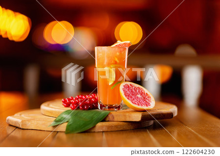 Glass of fresh orange juice with lemon, grapefruit and lime on a wooden board at festive blurred background. Glass of fresh orange juice with lemon, grapefruit and lime on a wooden board at festive blurred background. 122604230