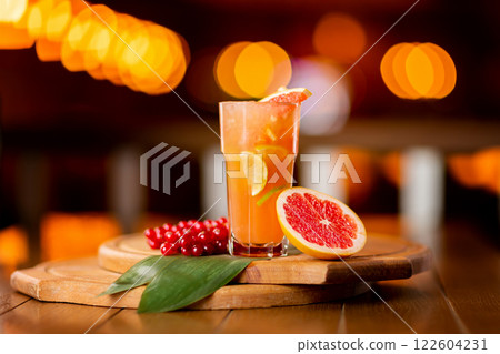 Glass of fresh orange juice with lemon, grapefruit and lime on a wooden board at festive blurred background. 122604231