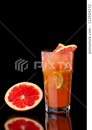 Closeup glass of citrus fresh juice with grapefruit, lime and lemon isolated at black background. 122604232