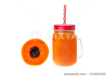 Closeup mug of orange papaya juice served with a straw and a half of papaya fruit isolated at white background. Closeup mug of orange papaya juice served with a straw and a half of papaya fruit isolated at white background. 122604280