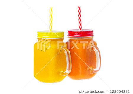 Two closeup glass jars of orange and yellow color smoothies with mango and papaya isolated at white background. Healthy vegan superfood lifestyle, detox dieting. 122604281