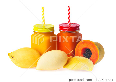 Two jars with tropical fruits juice and mango and papaya raw sliced fruits isolated at white background. Dieting, healthy lifestyle and detox. Two jars with tropical fruits juice and mango and papaya raw sliced fruits isolated at white background. Dieting, healthy lifestyle and detox. 122604284
