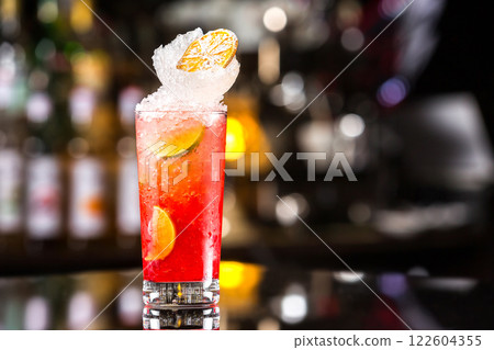 Glass of red fresh cocktail with lemon at bar counter background. 122604355