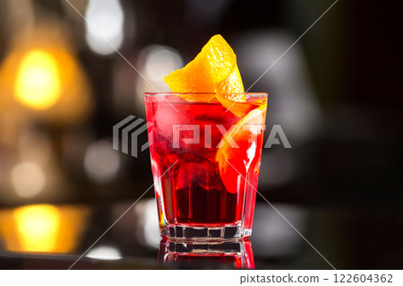 Closeup glass od red alcoholic cocktail decorated with lemon at bright bar stand background. Closeup glass od red alcoholic cocktail decorated with lemon at bright bar stand background. 122604362