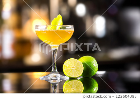 Closeup image of daiquiri cocktail decorated with lemon at bar counter background. Closeup image of daiquiri cocktail decorated with lemon at bar counter background. 122604383