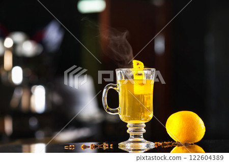 Closeup hot herbal tea with lemon at dark bar stand background. 122604389